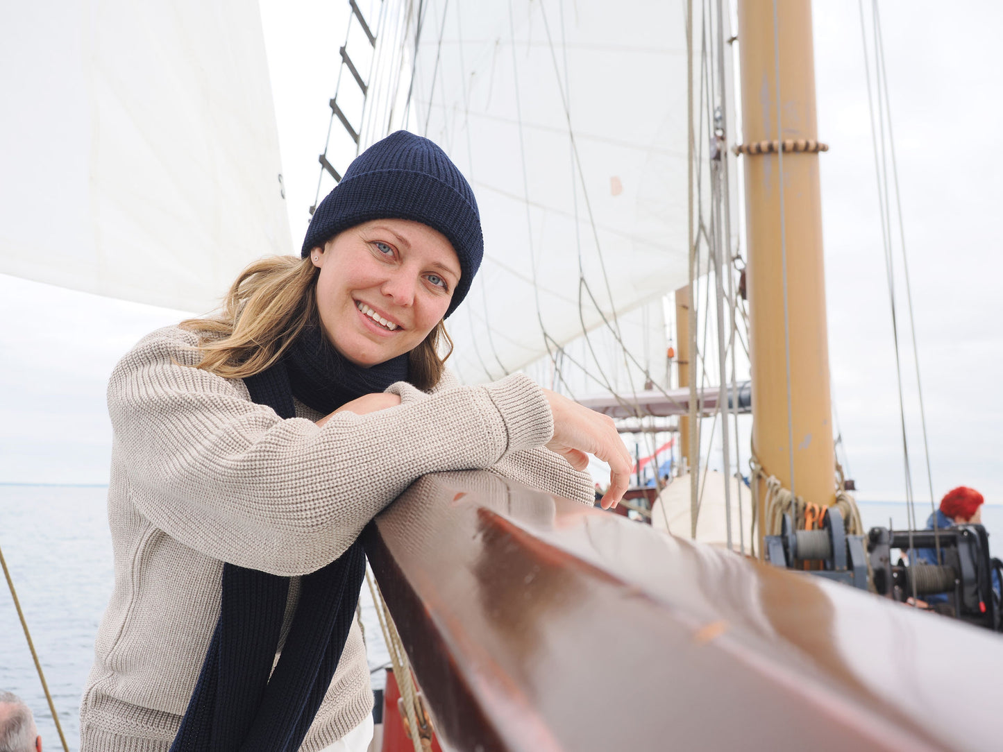 Frau mit Strickmütze und Schal von Blauer Peter auf einem Segelboot