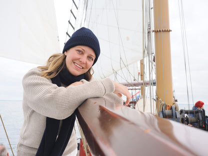 Frau mit Strickmütze und Schal von Blauer Peter auf einem Segelboot