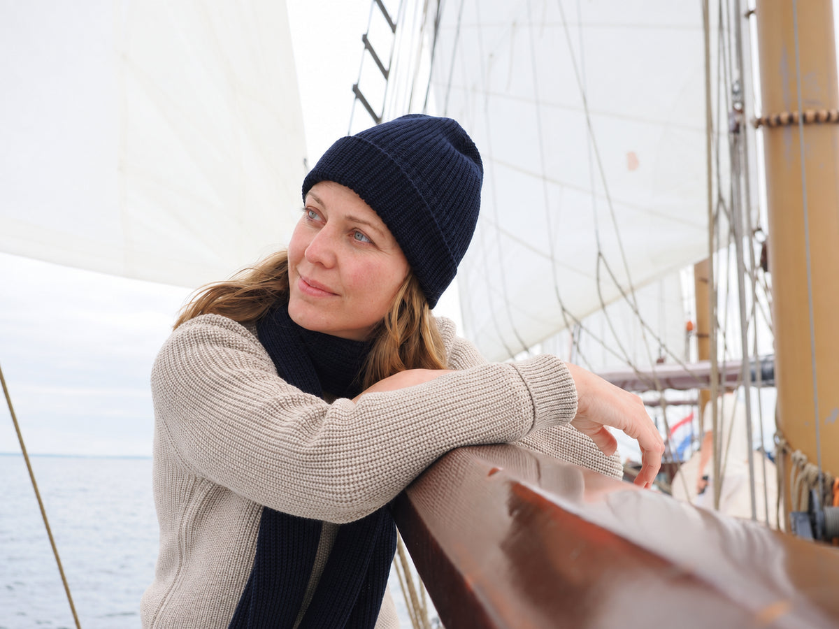 Frau Mit Strickmütze und Schal verträumt an Deck