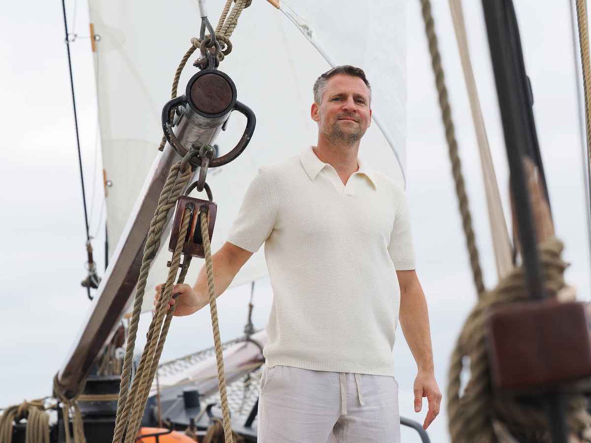 Mann in Heldenpose mit Poloshirt