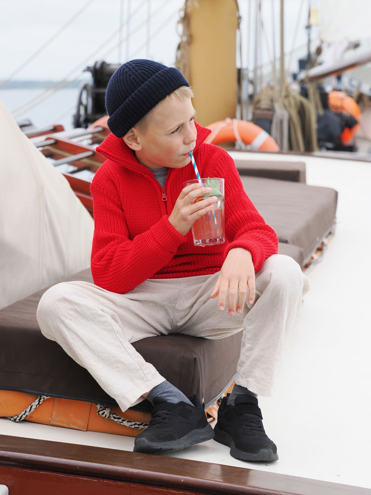 Junge mit Rollmütze auf einem Segelschiff