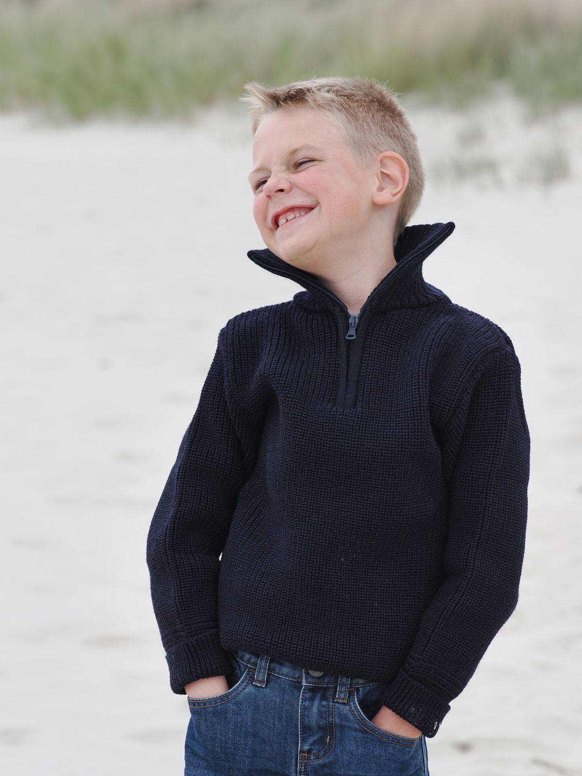 Junge mit blauem Troyer am Strand