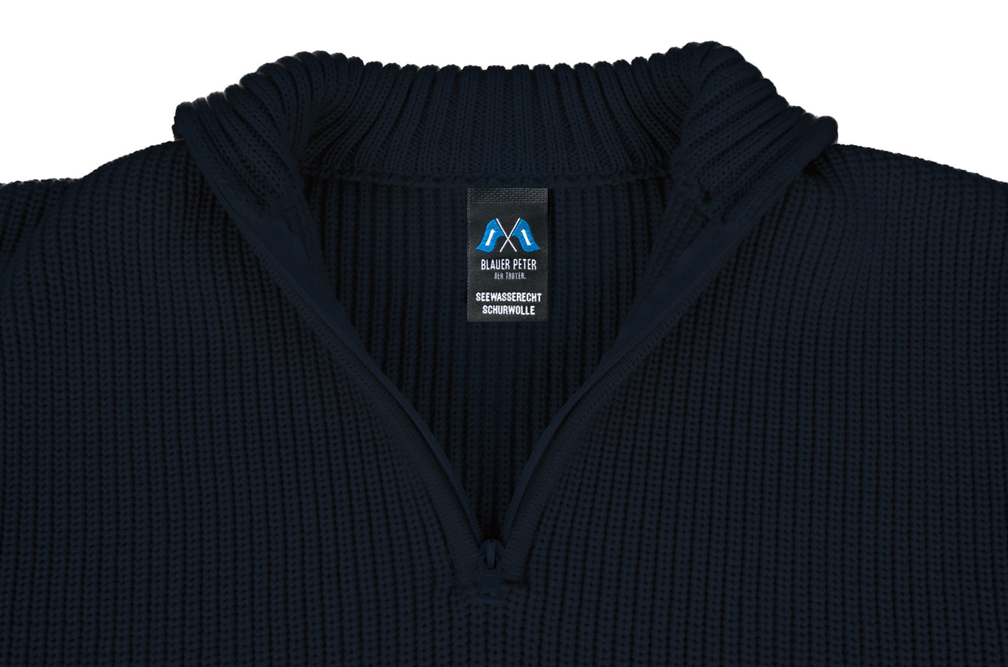 Nahansicht des Troyerkragens mit geöffnetem Reißverschluss, mit Fokus auf das Markenetikett