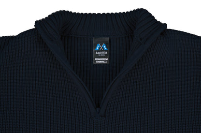 Nahansicht des Troyerkragens mit geöffnetem Reißverschluss, mit Fokus auf das Markenetikett